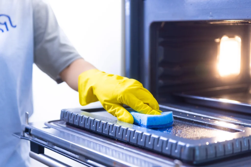 iemand die een oven deep clean doet van haar oven