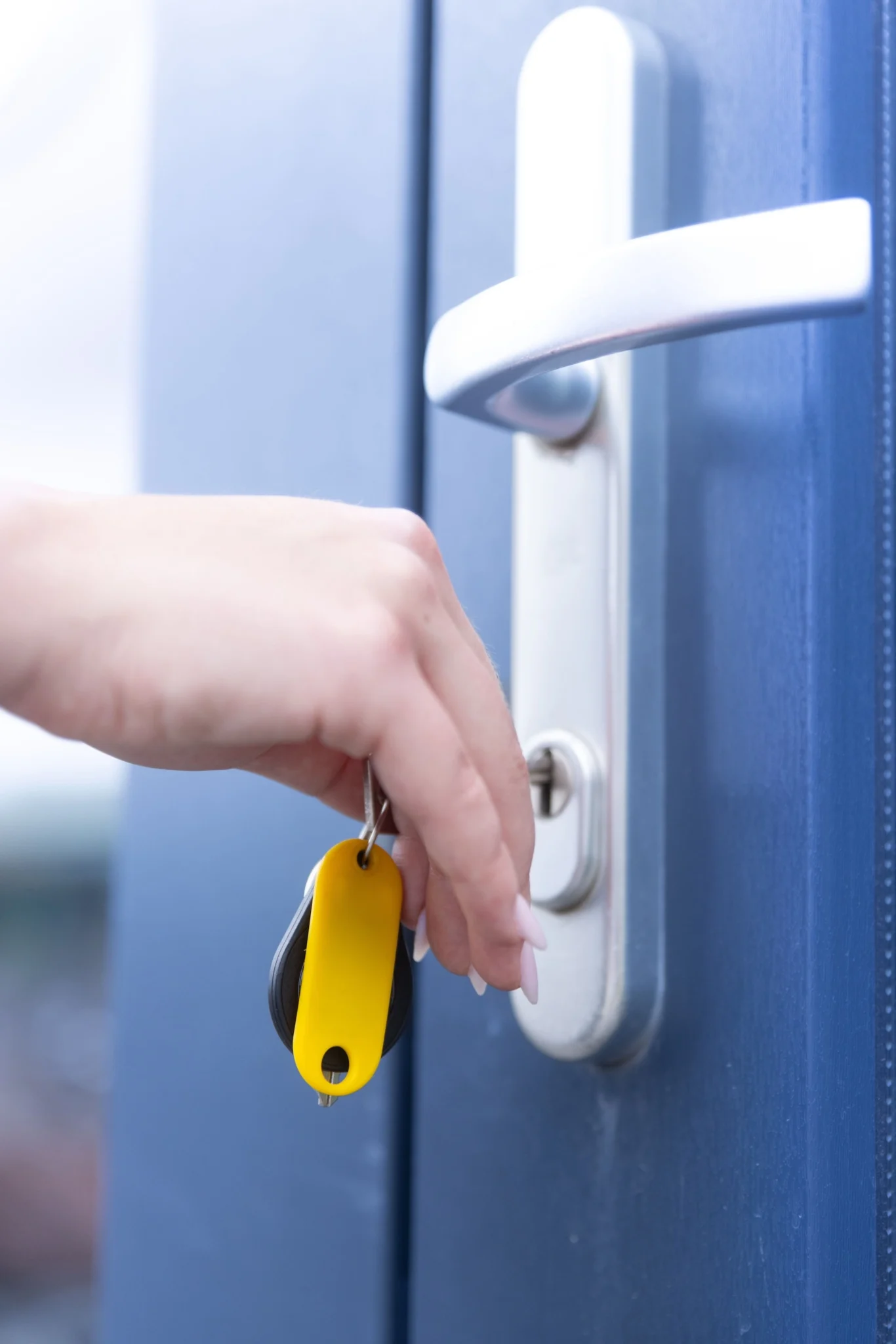 een hand die een sleutel in de deur doet